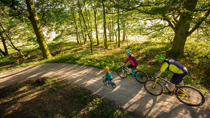 Family visitors cycling on one of Nostell's bike trails in Summer
